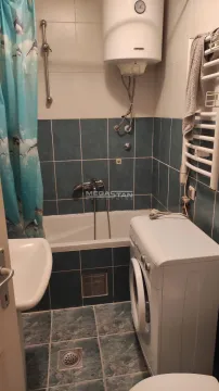 Manje kupatilo sa kadom, plavim pločicama i veš mašinom. - image 9