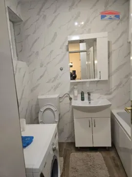 Kupatilo opremljeno sanitarijama, umivaonikom sa ormarićem i mašinom za veš. - image 20