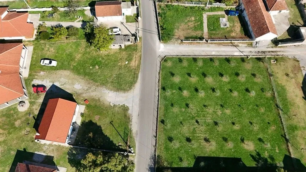 Pogled iz vazduha na plac sa voćnjakom i okolne kuće.