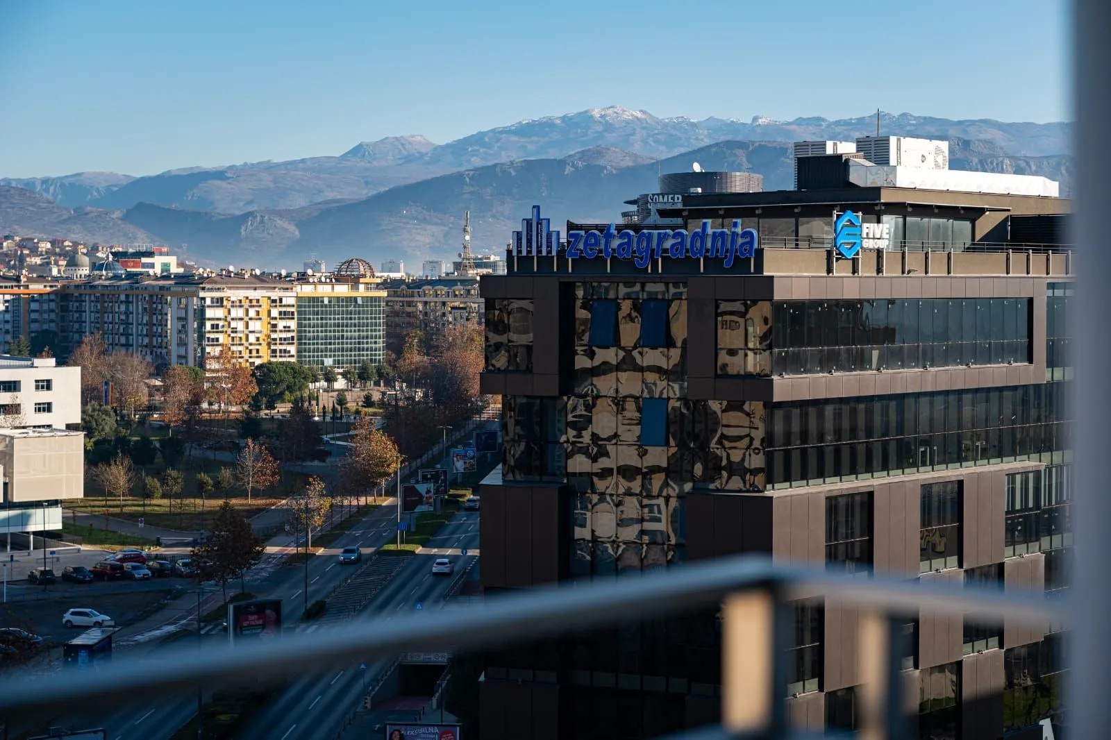 View from the window overlooking surrounding buildings and distant mountains.
