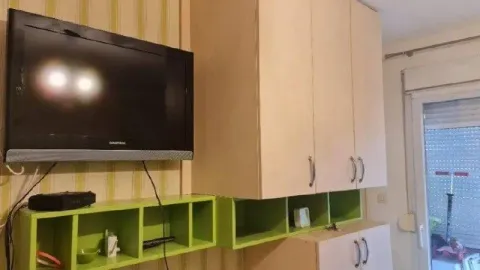 Dnevni boravak sa televizorom i drvenim elementima. - image 6