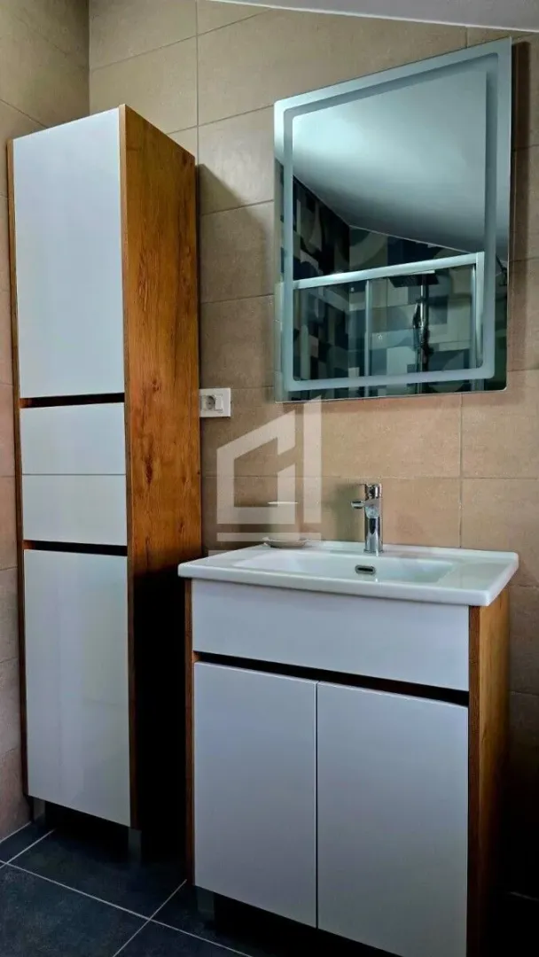 Bathroom with a washbasin, mirror and a tall cabinet.