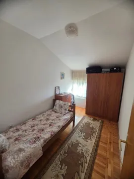 Manja spavaća soba sa krevetom, ormarom i drvenim podom. - image 6