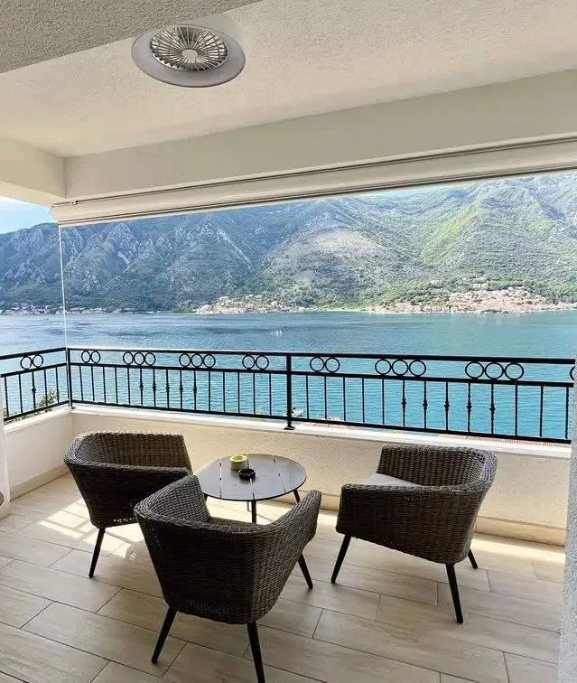 Natkrivena terasa sa garniturom za sjedenje i pogledom na more i planine.