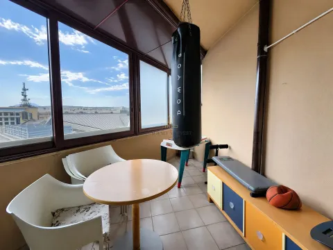Enclosed balcony with seating furniture and sports equipment. - image 11