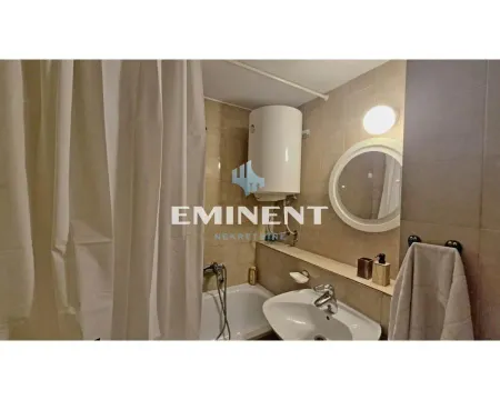 Bathroom equipped with a sink, bathtub with a curtain, and a water heater. - image 11