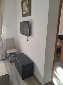 Smaller living room with a wall-mounted TV and a chest of drawers. - image 10