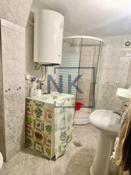 Bathroom with a shower cabin, washbasin, and water heater. - image 6