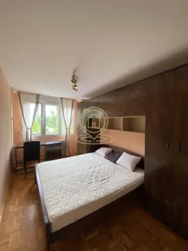Nameštena spavaća soba sa bračnim krevetom, velikim ormanom i radnim stolom pored prozora. - image 6