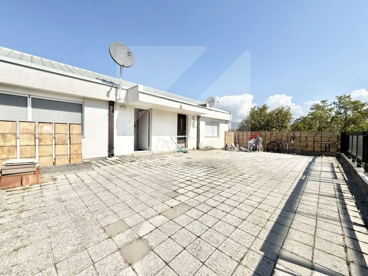Large paved terrace in front of the building entrance.