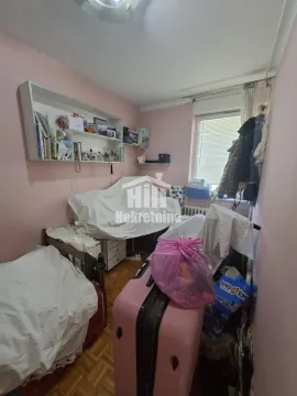 Manja spavaća soba sa krevetom, radnim stolom i policama na zidu. - image 7