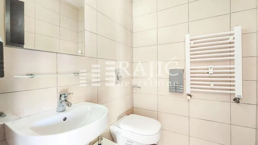 Small bathroom with a sink, toilet, and a white wall radiator.