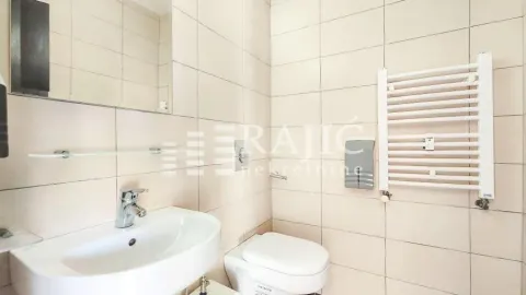 Small bathroom with a sink, toilet, and a white wall radiator. - image 4