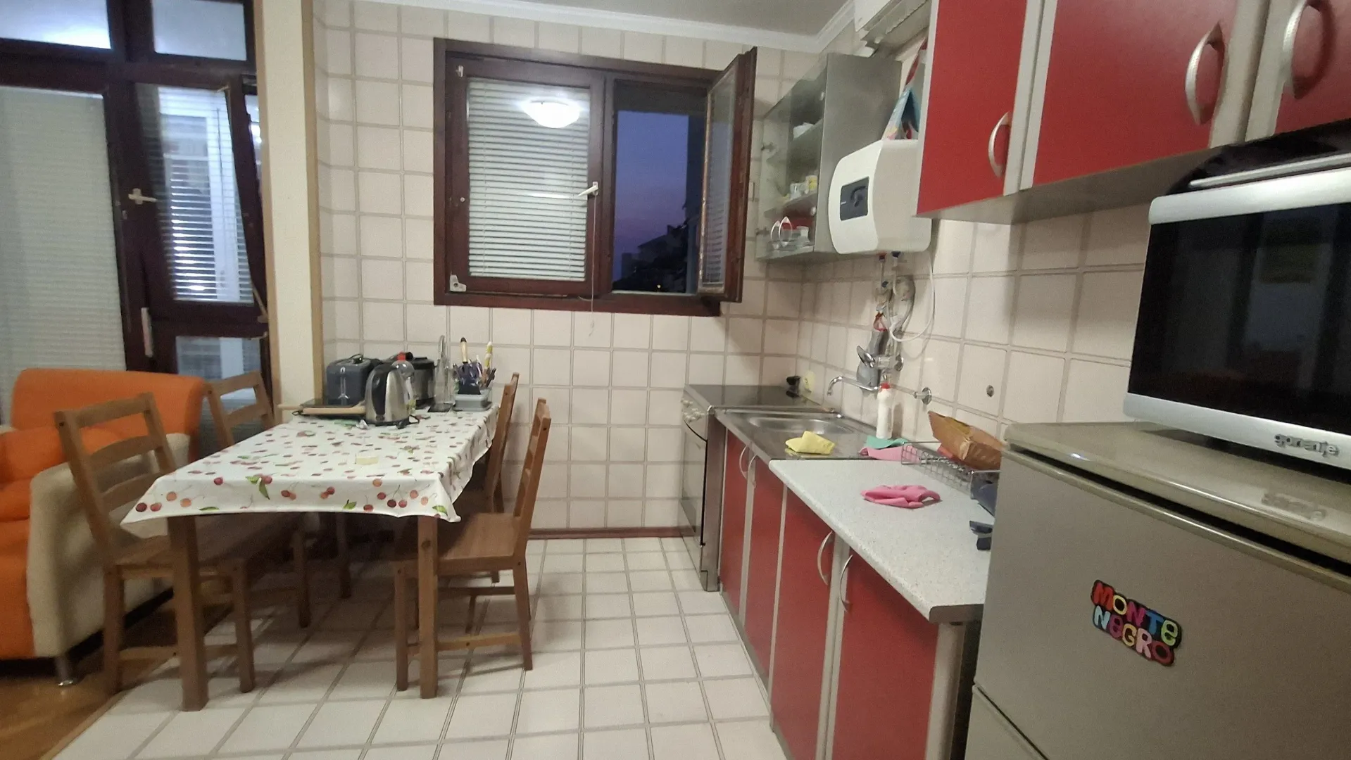 Manja kuhinja sa trpezarijskim stolom i stolicama u stanu.