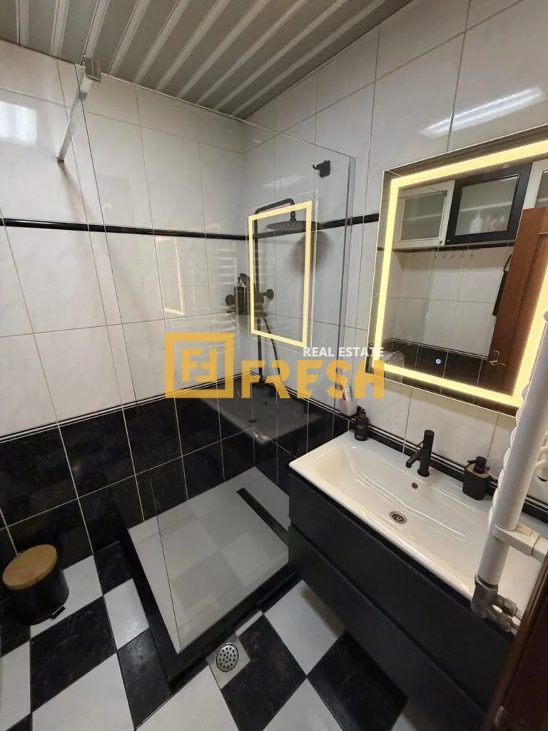 Modern bathroom with a walk-in shower and a sink.