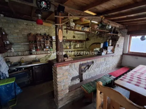 Rustična kuhinja sa drvenim elementima, šankom i trpezarijskim stolom. - image 3