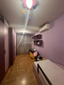 Children's bedroom with a bed, wardrobe, and parquet flooring. - image 9