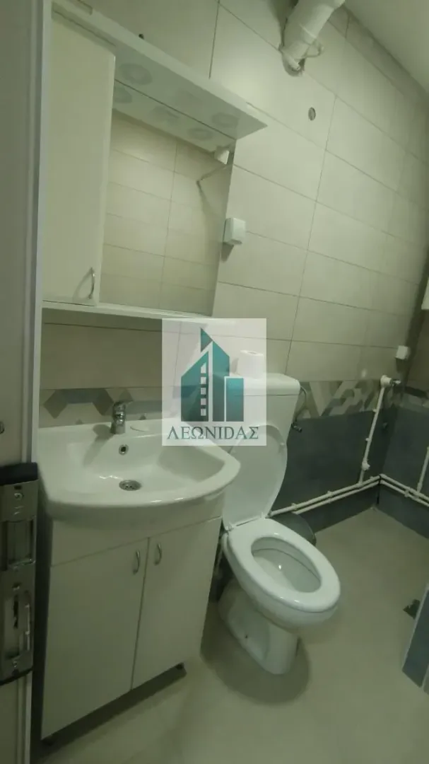 Small bathroom with a sink, cabinet, and toilet.