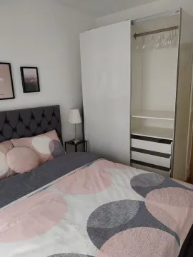 Bright bedroom with a double bed and a white wardrobe. - image 10