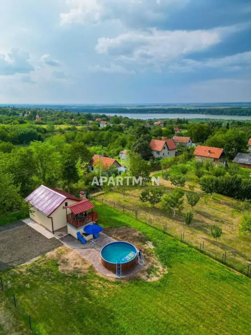 Pogled iz vazduha na kuću sa bazenom i velikim dvorištem u prizemnom naselju.