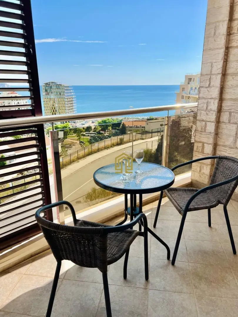 Furnished terrace with a table, chairs, and sea view.