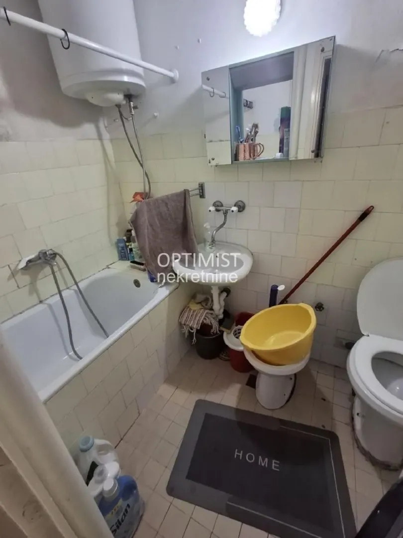 Manje opremljeno kupatilo sa kadom, umivaonikom i toaletom.