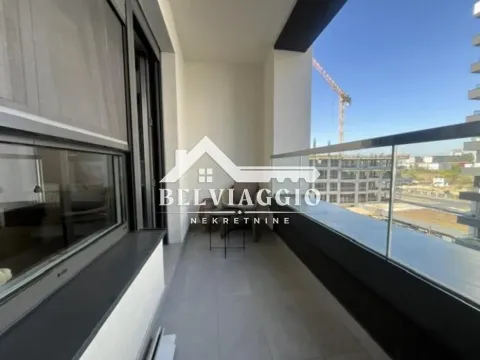 Covered balcony with glass railing and city view. - image 20
