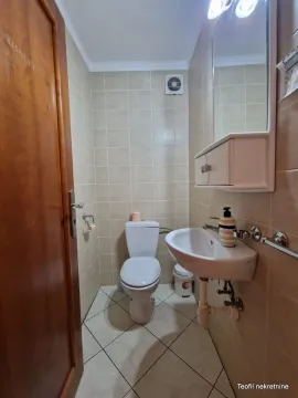 Small bathroom with a toilet, washbasin, and a mirror with a cabinet. - image 4