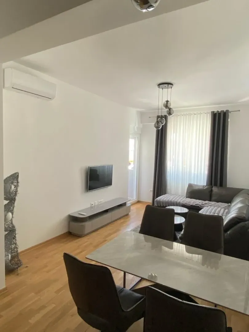 Living room with dining area, sectional sofa, and TV.