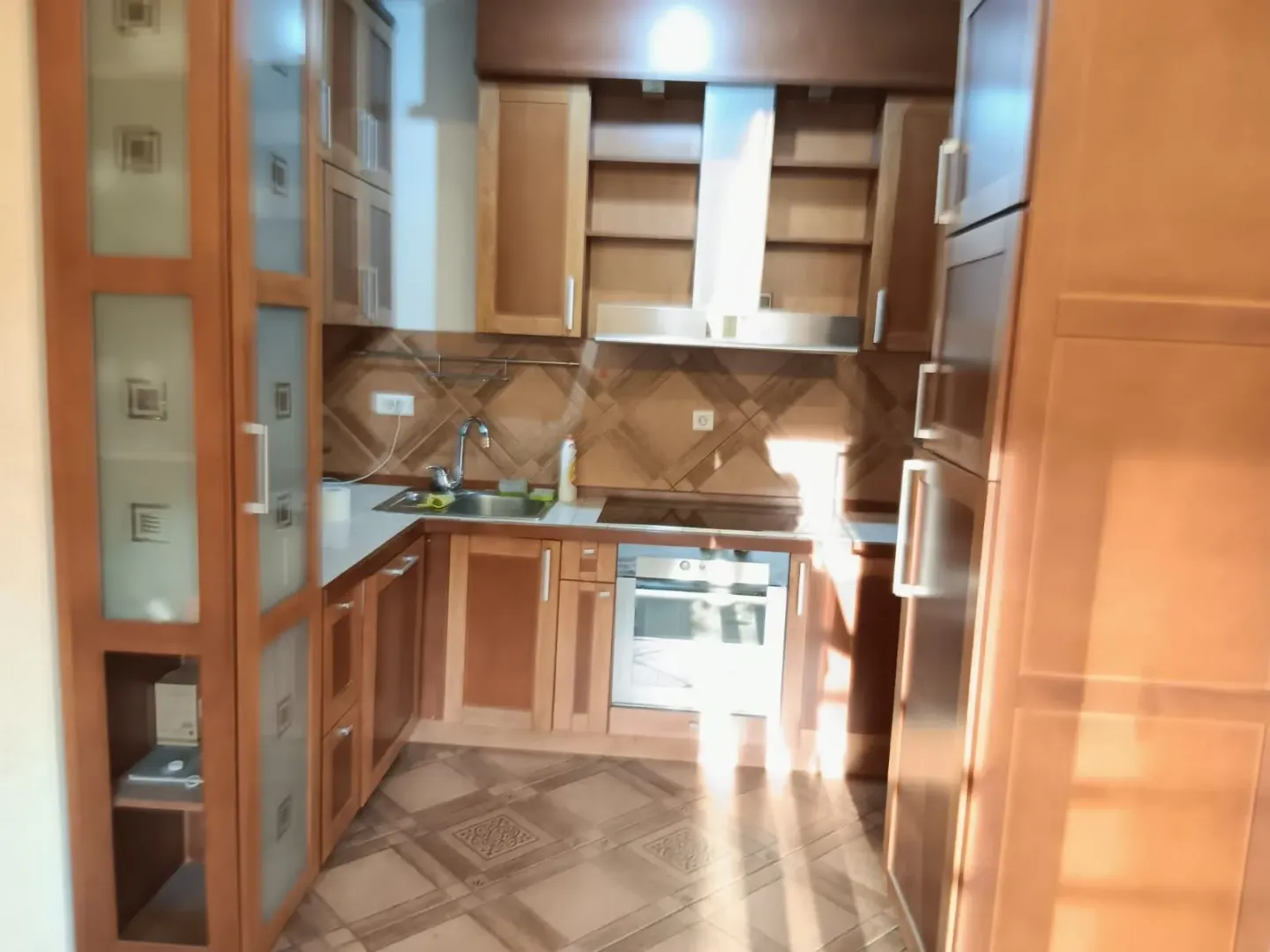 Wooden kitchen with built-in appliances and a sink.