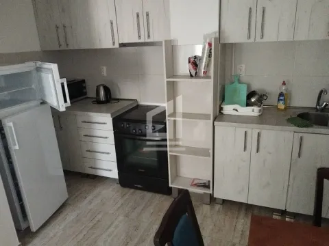Manja kuhinja opremljena bijelim elementima, šporetom i frižiderom. - image 2