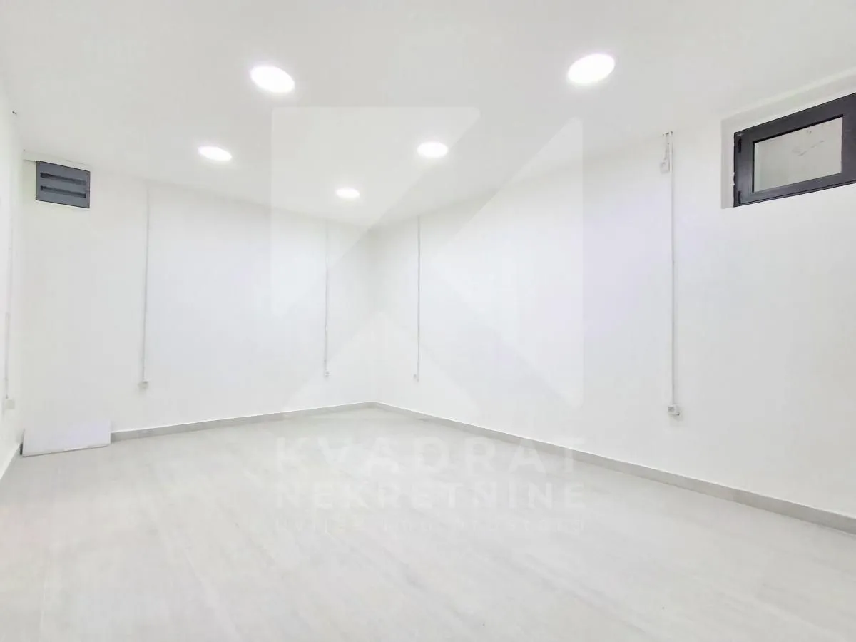 Empty bright room with white walls and recessed lighting.
