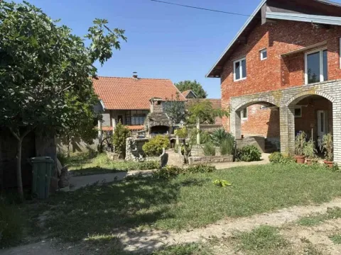 Dvorište sa travnjakom, drvećem i pogledom na kuću i pomoćni objekat. - image 3
