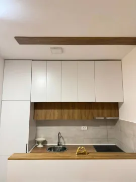 Pogled na moderno opremljenu kuhinju sa bijelim i drvenim elementima. - image 4