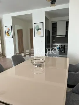 Dining area with a table and chairs, overlooking the kitchen and hallway. - image 5
