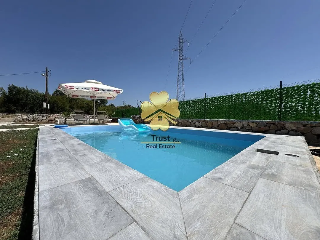 Yard with a swimming pool and paved patio.