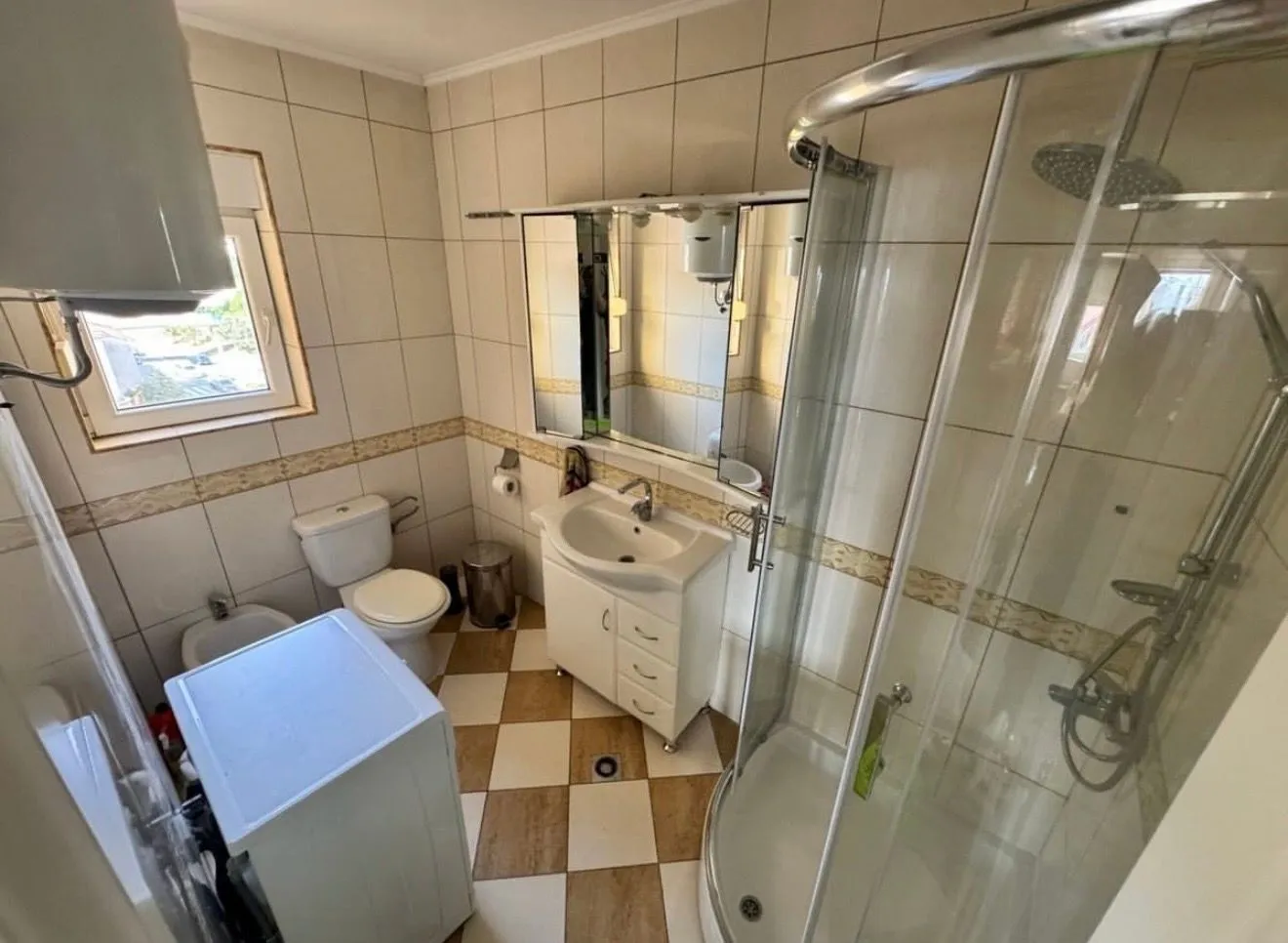 Kompaktno kupatilo sa tuš kabinom, umivaonikom, wc šoljom i veš mašinom.