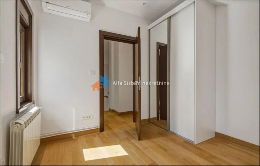 Smaller bedroom with a built-in wardrobe and hardwood flooring.