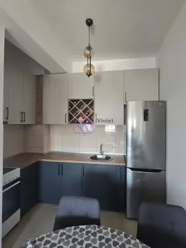 Compact kitchen with two-tone cabinetry, built-in appliances, and a refrigerator. - image 4