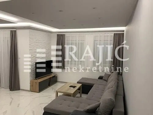 Modern living room with a sofa and TV unit.