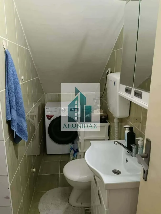 Manje kupatilo sa umivaonikom, WC šoljom i veš mašinom.