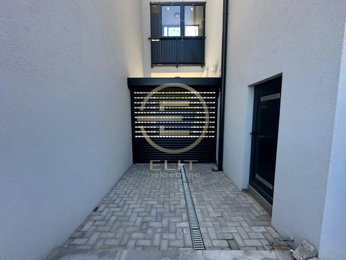 View of the paved entrance and garage doors of the building.
