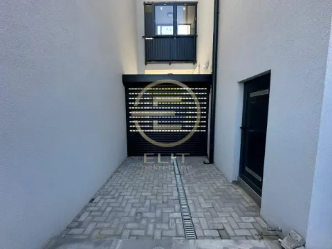 View of the paved entrance and garage doors of the building. - image 10