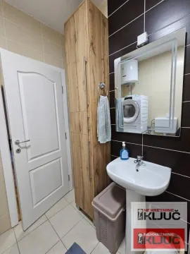 Kupatilo sa umivaonikom, ogledalom, visokim drvenim ormarićem i mašinom za veš. - image 14