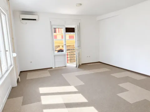 Prazna soba sa belim zidovima, tepihom i balkonskim vratima. - image 9