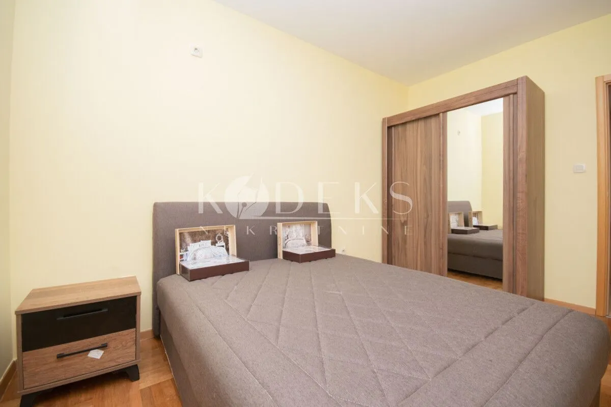 Furnished bedroom with a double bed, nightstand, and wardrobe.