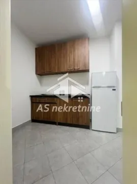 Small kitchen with wooden cabinets and a refrigerator. - image 7