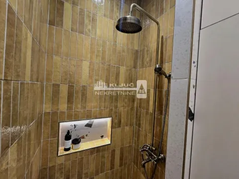Walk-in shower with gold-toned wall tiles and a built-in niche. - image 5