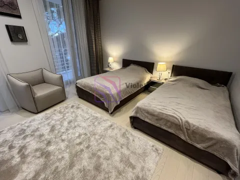 Bedroom with two single beds, an armchair, and a rug. - image 11