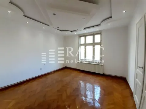 Empty room with parquet flooring and a dropped ceiling. - image 2